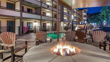 A multi-story hotel with outdoor seating and a fire pit.
