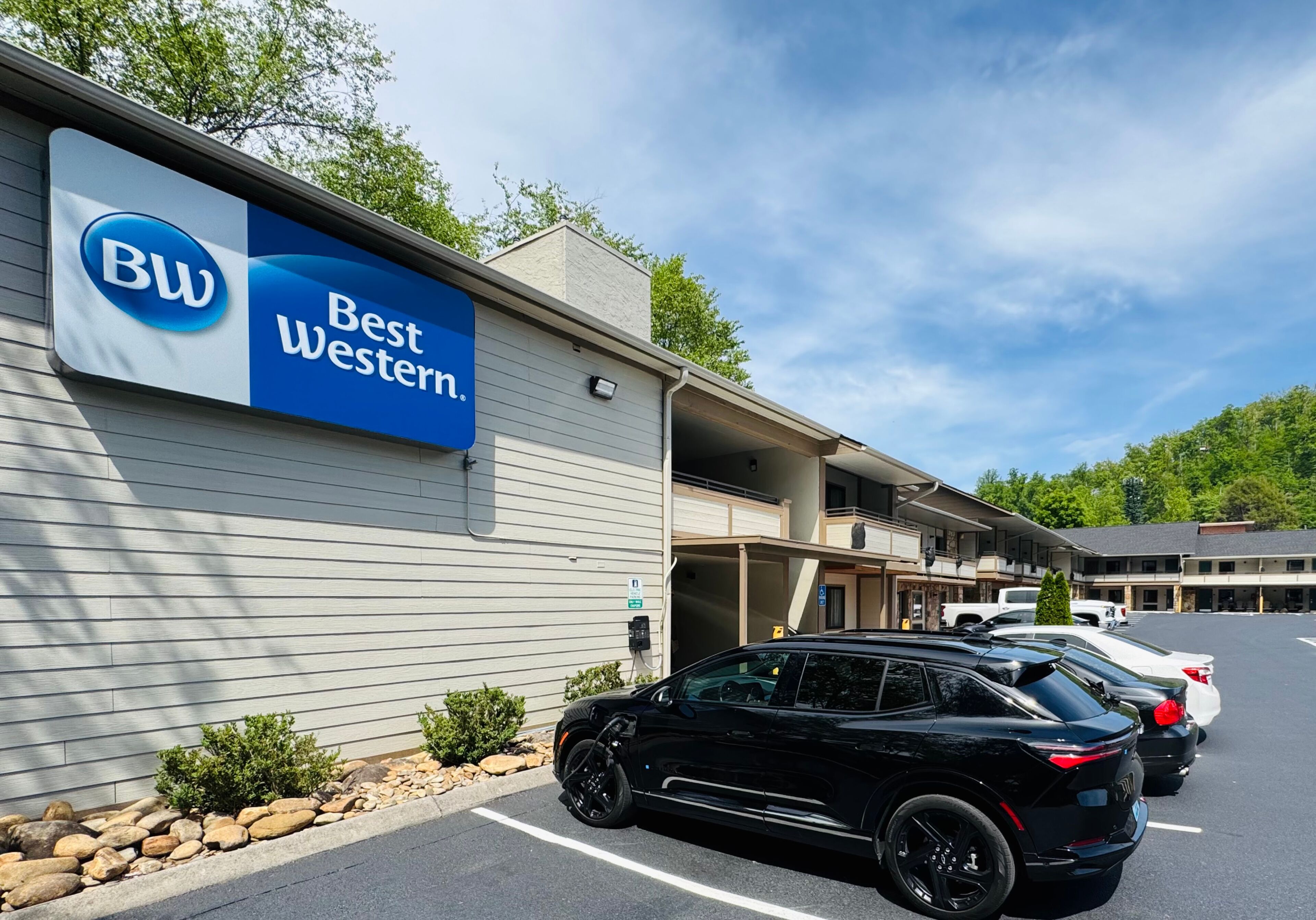 A Best Western hotel with a parking lot and several cars parked.
