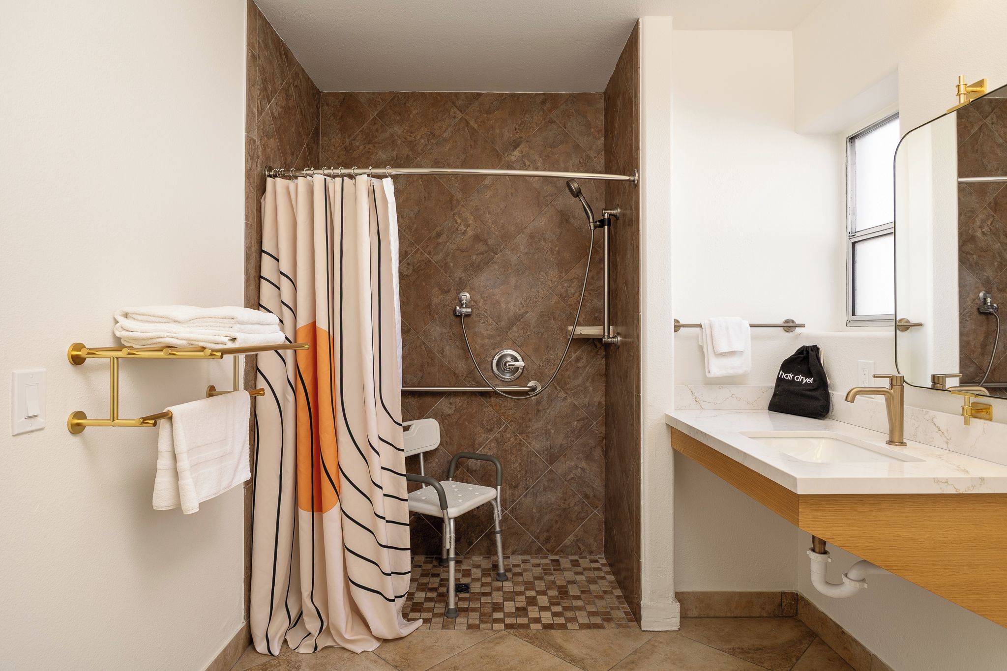 Un baño con ducha, inodoro, lavabo y toallero.