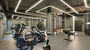 A modern gym with treadmills, elliptical machines, and a bench. - DoubleTree by Hilton Vienna Bosei (Vienna)