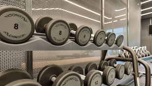 A row of dumbbells on a rack with visible weight markings. - DoubleTree by Hilton Vienna Bosei (Vienna)