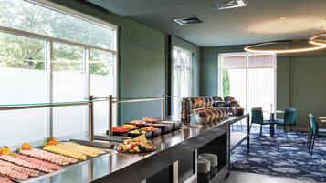 A buffet area with various food items and a seating arrangement with chairs and a table.