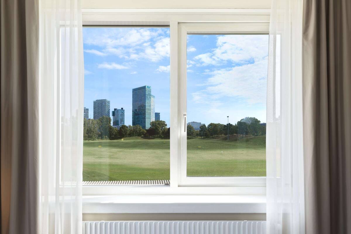 A window with a view of a cityscape and a park.