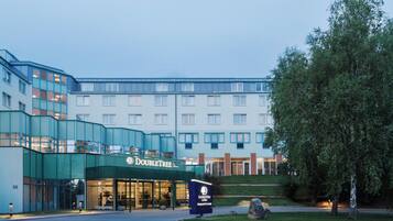 A hotel with a modern design, featuring a prominent entrance with glass doors and a sign for the DoubleTree by Hilton.