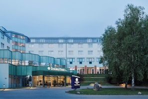 Un hotel de diseño moderno, con una entrada destacada que cuenta con puertas de vidrio y un letrero de DoubleTree by Hilton.