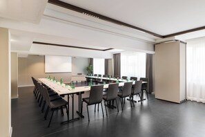 A conference room with a long table, chairs, and water bottles. - DoubleTree by Hilton Vienna Bosei (Vienna)