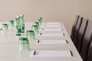 A conference table with green glass bottles and name cards. - DoubleTree by Hilton Vienna Bosei (Vienna)