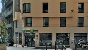 Un hôtel moderne, avec plusieurs étages, de grandes fenêtres et une façade plate.