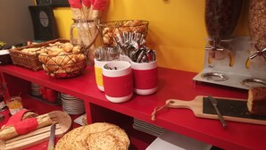 Un buffet de petit-déjeuner proposant une variété d'aliments, de couverts et un tableau noir sur lequel est dessiné un gâteau.