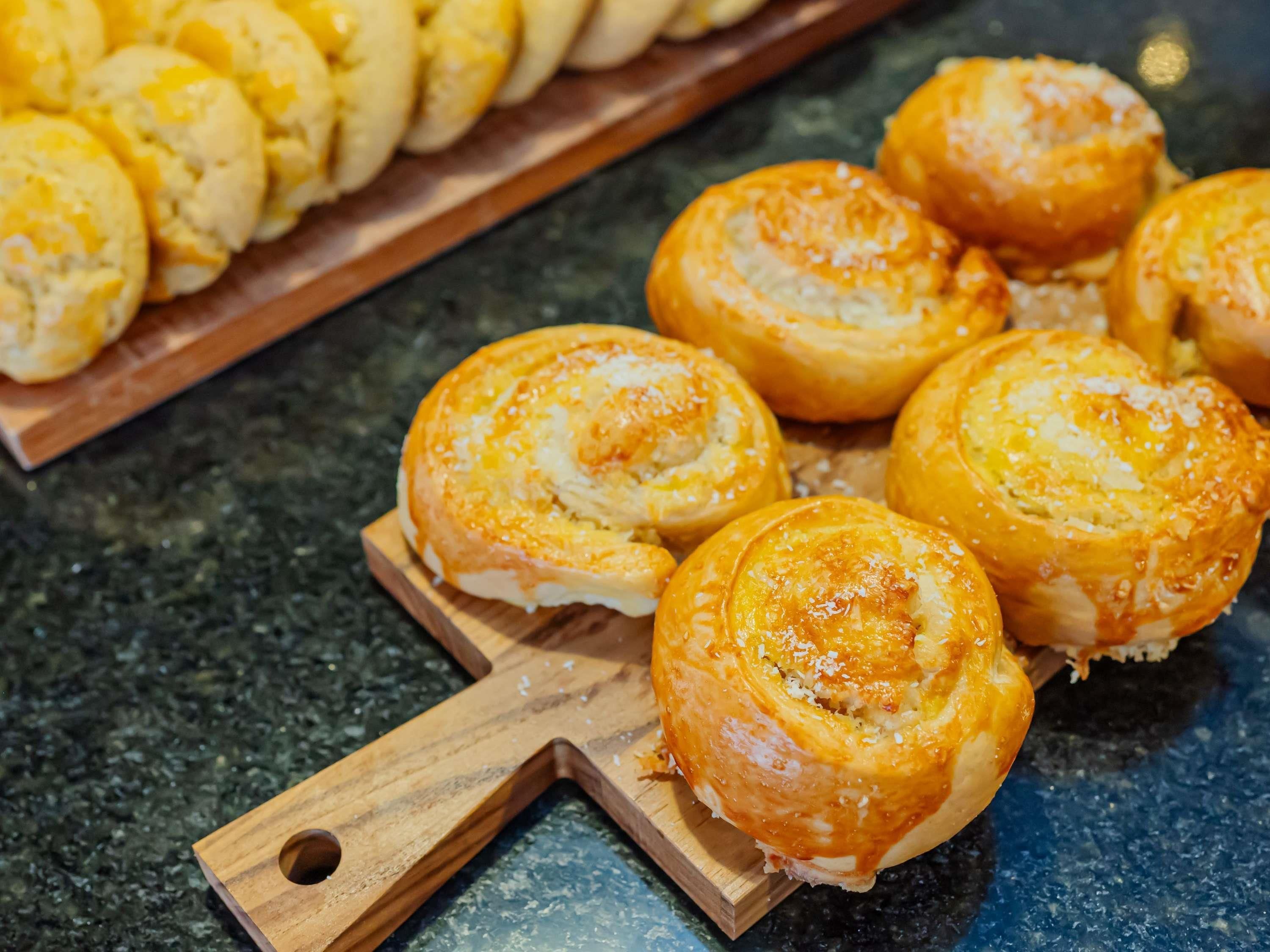 A wooden cutting board with pastries on a countertop.