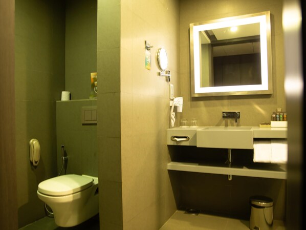 A bathroom with a toilet, sink, and mirror. - Novotel Kolkata Hotel & Residences Hotel (Barasat)