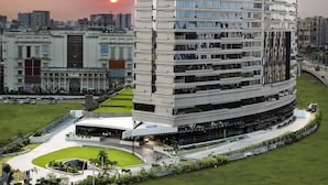 Un hotel moderno con fachada curva, varios balcones y un patio central.