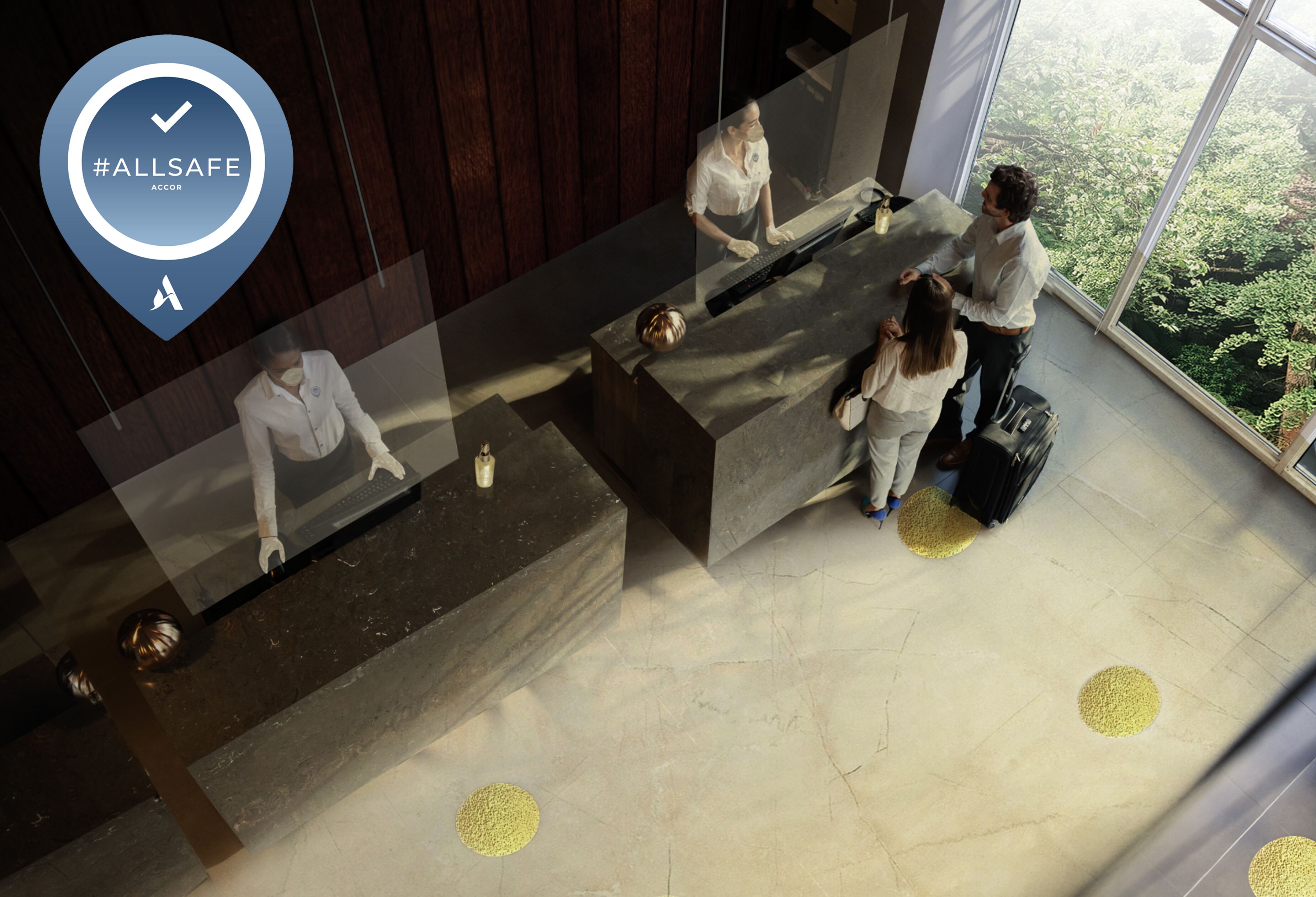 A reception desk with a glass partition, a check-in counter, and a view of the outdoors through large windows.