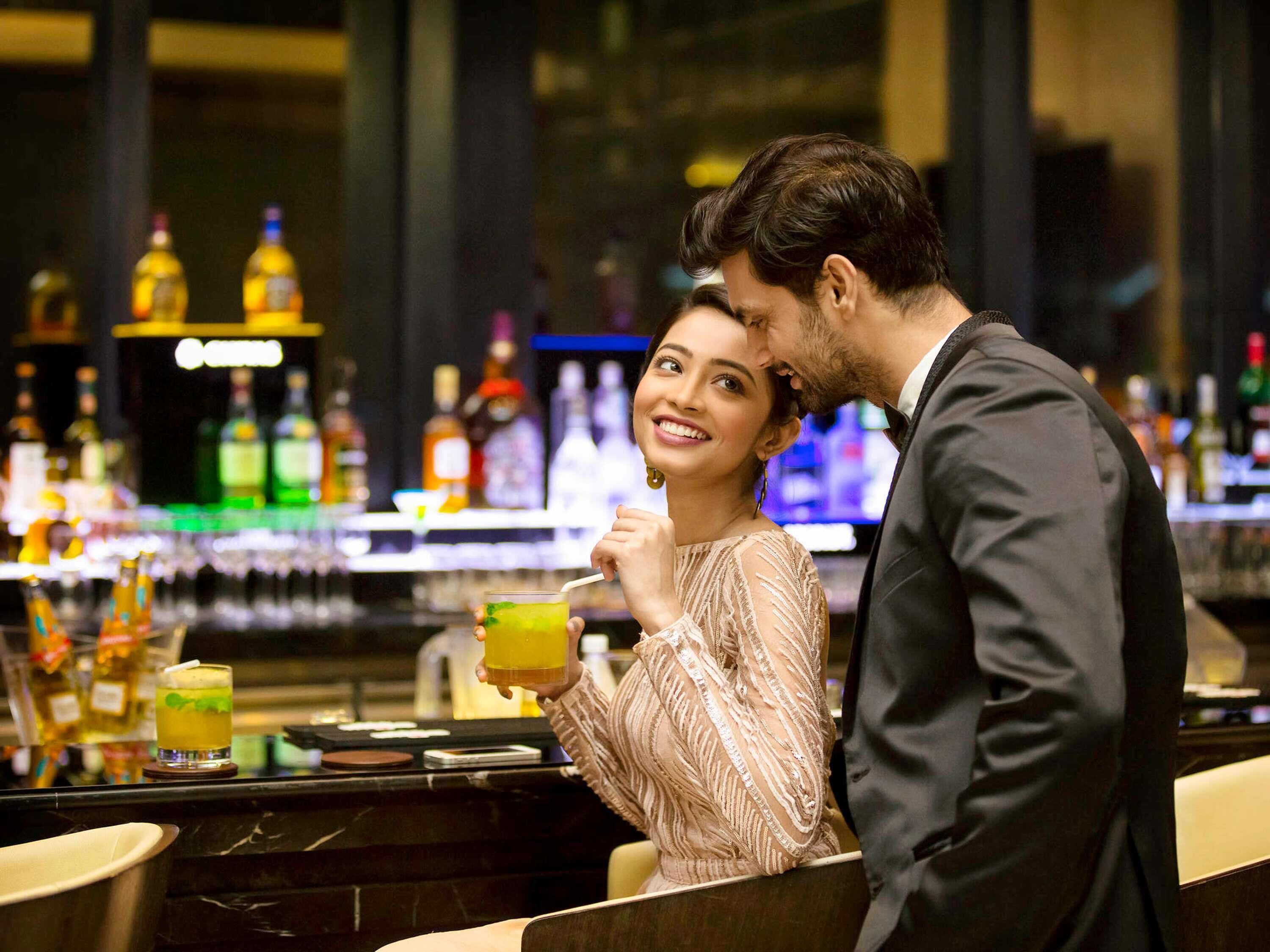 A bar area with a counter and various bottles in the background.