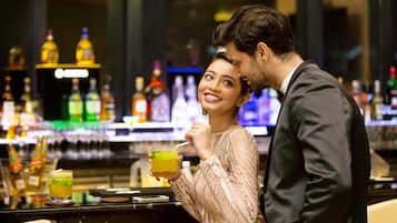 A bar area with a counter and various bottles in the background.
