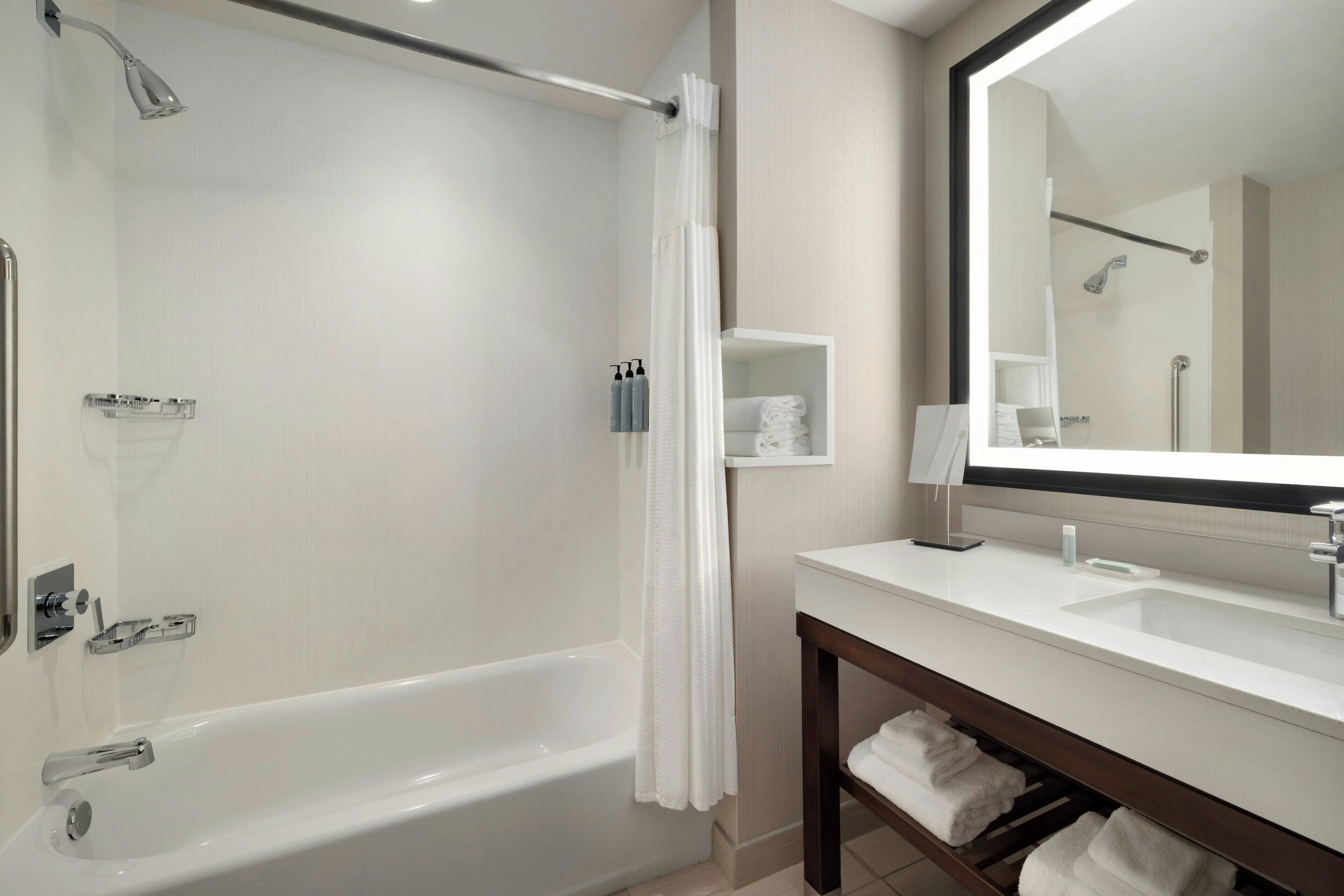 Un bagno moderno con una vasca, una doccia, un lavandino e un grande specchio.