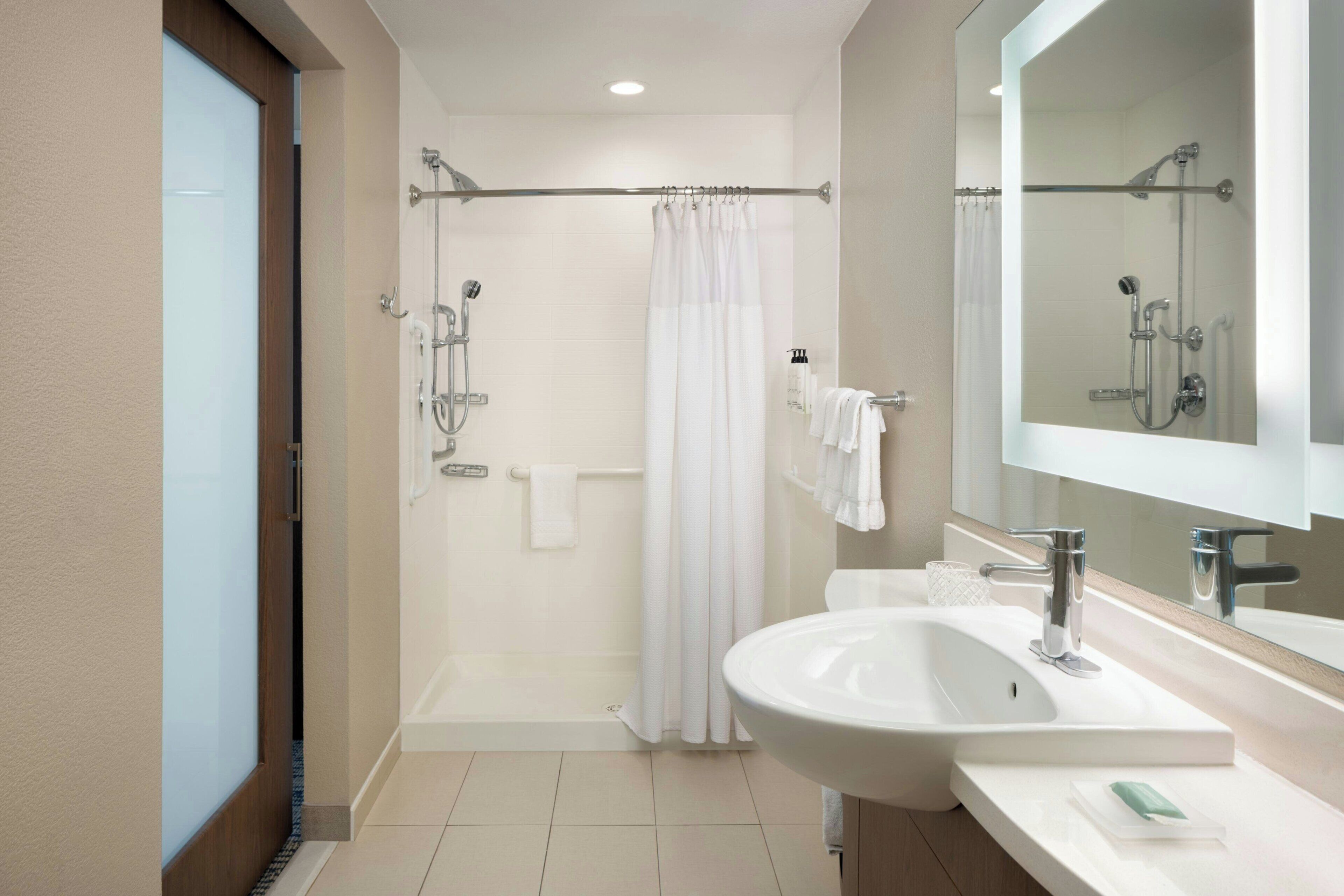A modern bathroom with a bathtub, shower, and sink.