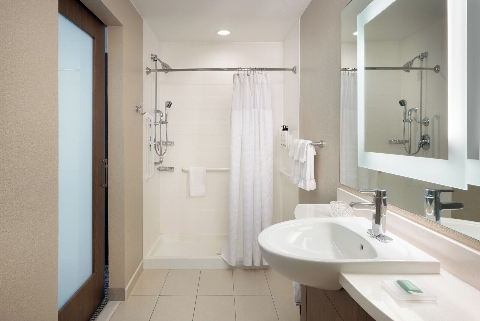 Une salle de bain moderne équipée d’une douche, d’une baignoire, d’un lavabo et d’un grand miroir.