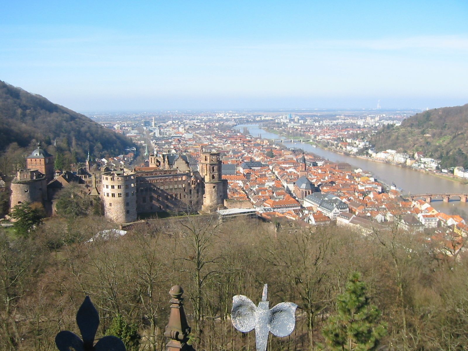 A historic cityscape with a prominent castle and a river.