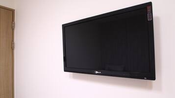 A black flat-screen TV mounted on a white wall.