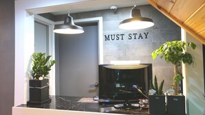 Ein modernes Badezimmer mit schwarzem Waschtisch, zwei Pendelleuchten, einem Spiegel und einem Schild mit der Aufschrift 'MUST STAY'.
