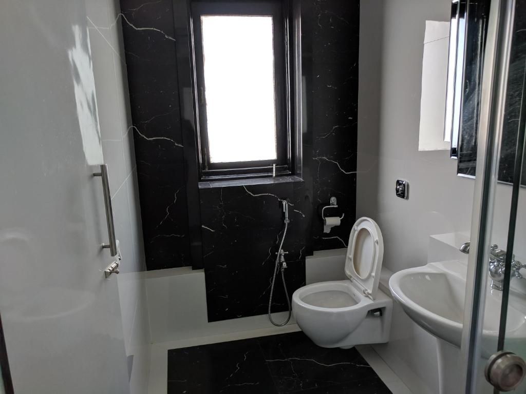 Une salle de bain équipée de toilettes, d’un bidet et d’un lavabo.