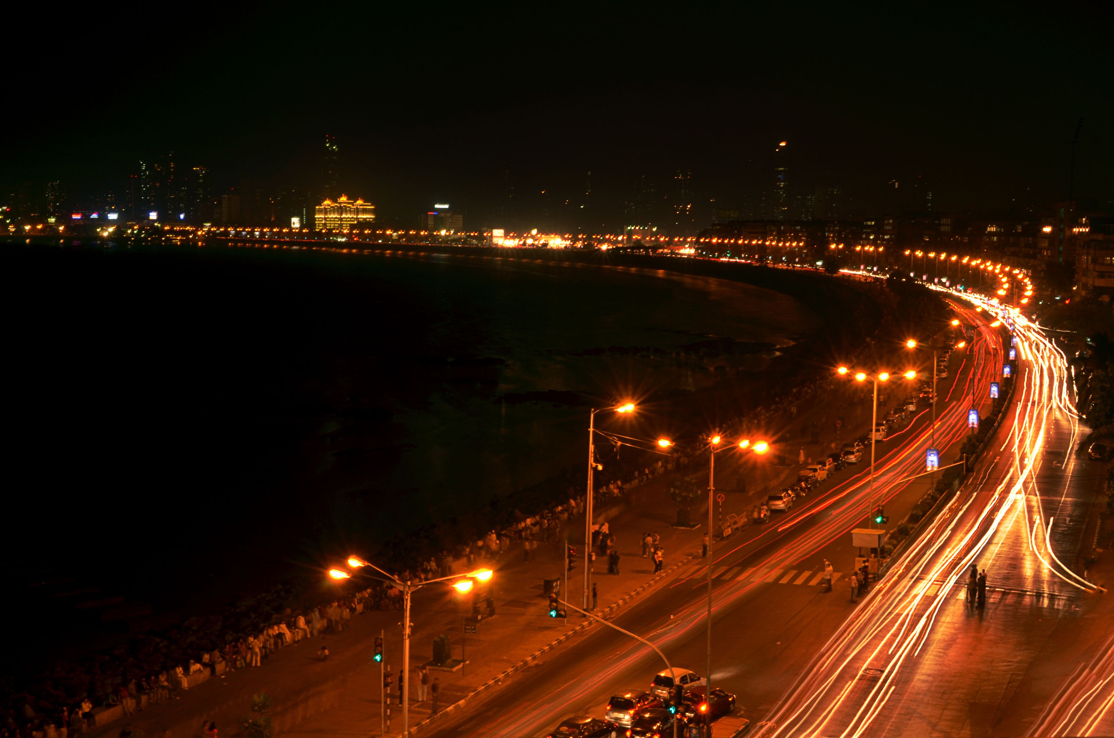 A nighttime cityscape with a curved road and streetlights.