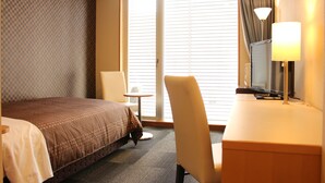 A hotel room with a bed, a desk, a chair, a lamp, and a window with blinds. - Hotel Livemax Chiba Mihama (Chiba)