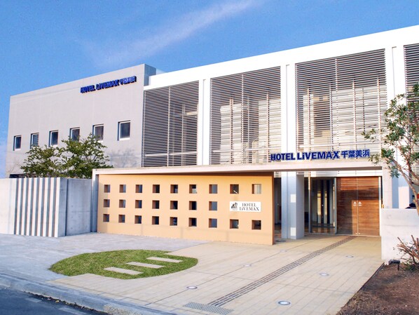 A modern hotel building with a prominent sign reading "HOTEL LIVINGMAX". - Hotel Livemax Chiba Mihama (Chiba)
