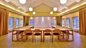 A conference room with a long table, chairs, and a projection screen. - Hotel Morgenland (Berlin)
