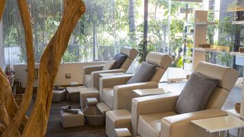 Un área de estar moderna con diversas opciones de asientos, incluyendo sofás y sillones, dispuestos alrededor de una mesa central.