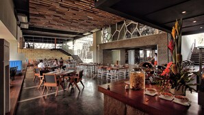 Un restaurante espacioso con techos altos, diseño moderno y vistas al exterior.