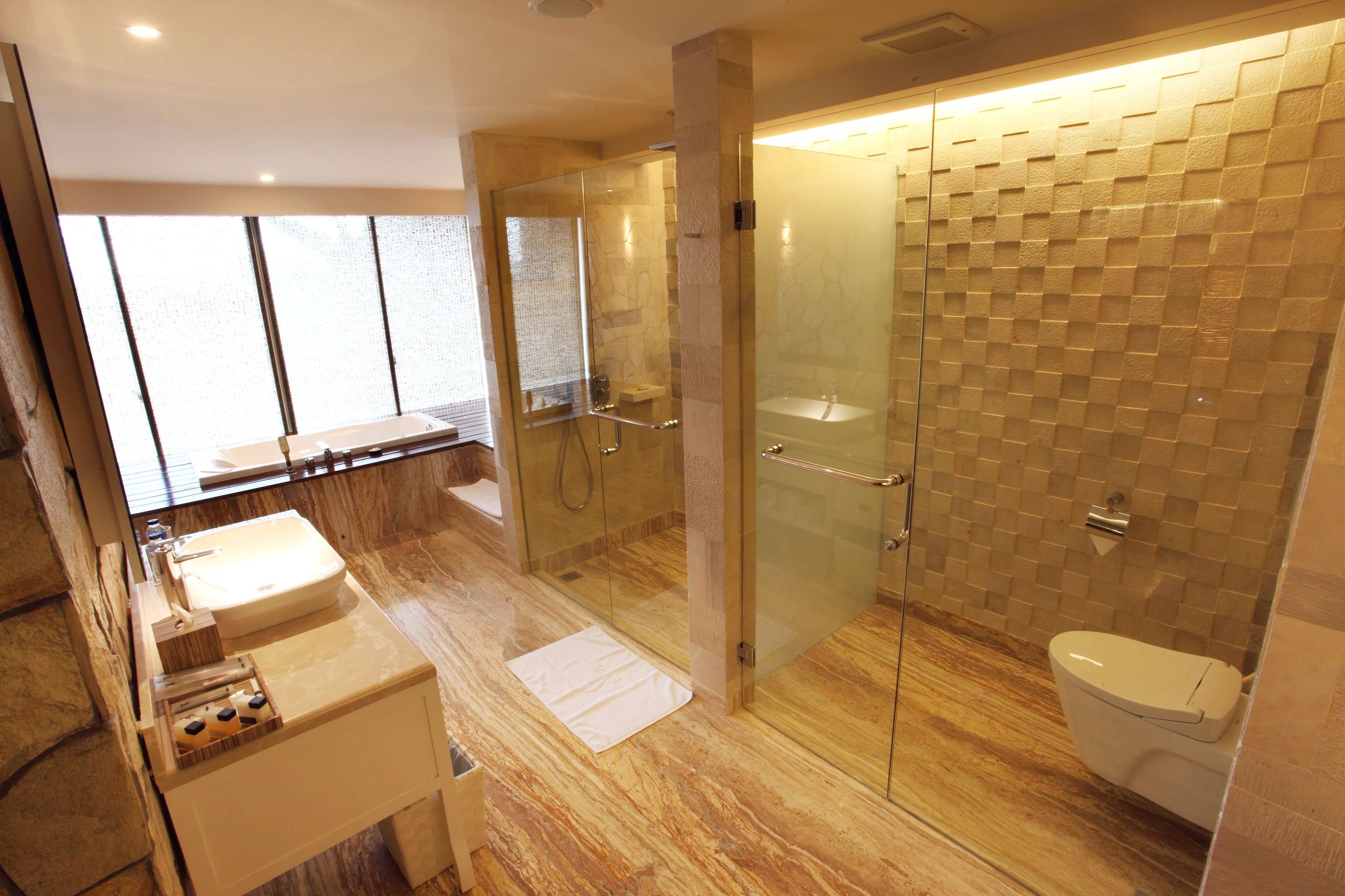 A modern bathroom with a glass-enclosed shower, a sink, and a toilet.