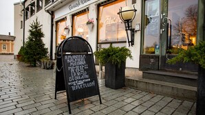 Un restaurante con un letrero que muestra su nombre y horario de atención.
