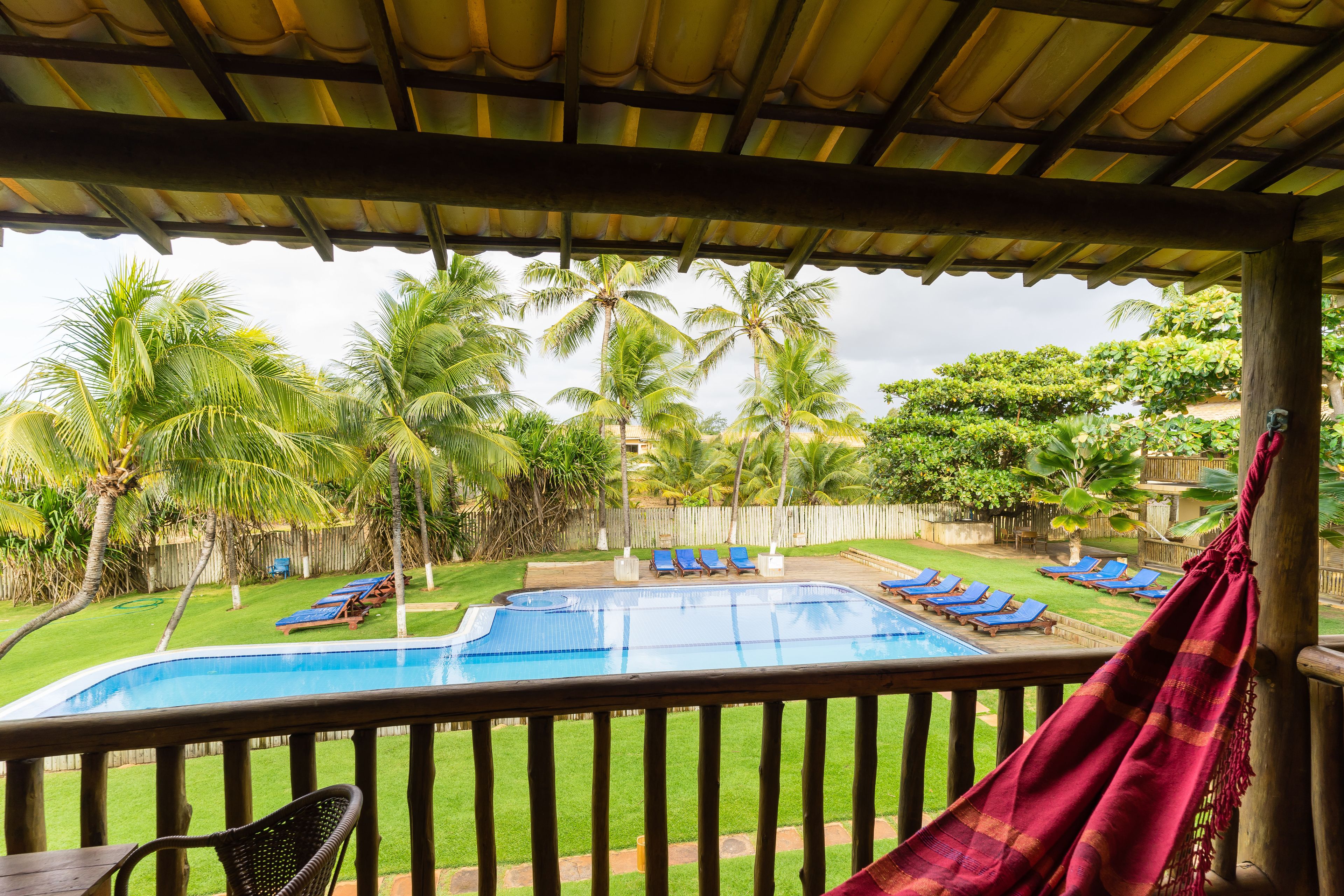 A pool area with lounge chairs and palm trees.