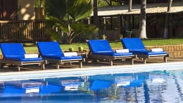 Uma área à beira da piscina com espreguiçadeiras e piscina.