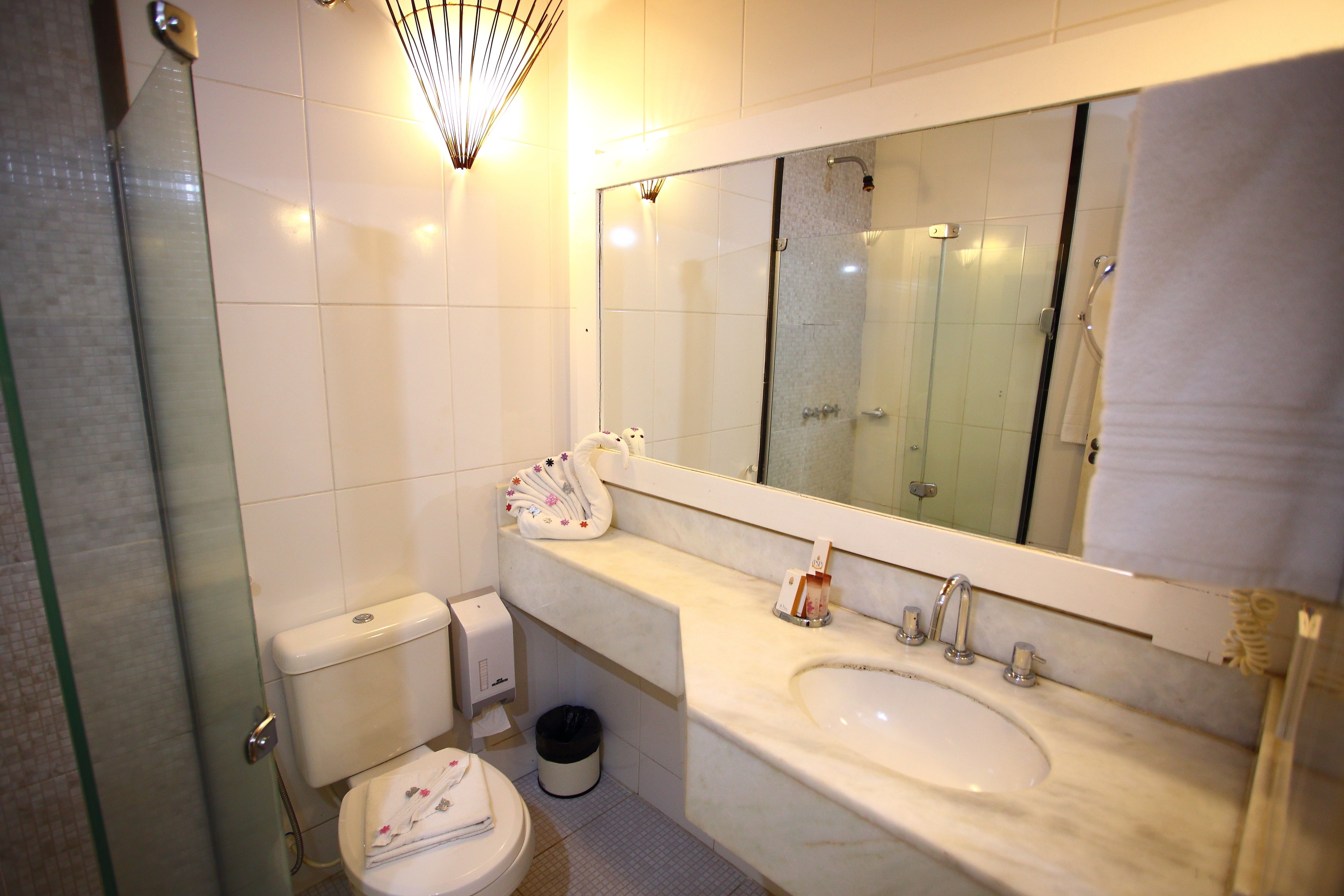 Une salle de bain avec des toilettes, un lavabo et une douche.