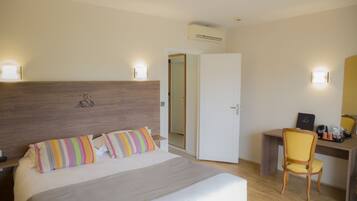 Una habitación de hotel con cama, mesita de noche, escritorio y silla.