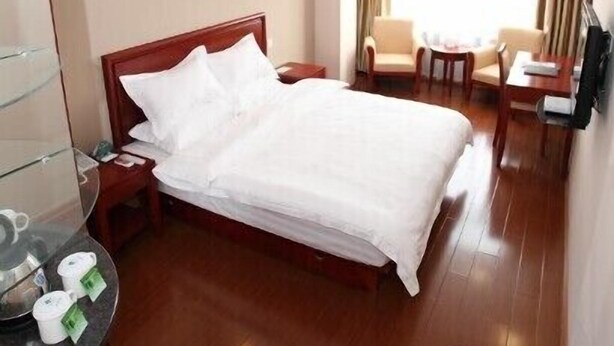 A hotel room with a bed, a desk, a chair, a TV, and a window with curtains. - GreenTree Inn Nantong Rugao Port Bus Station Business Hotel (Nantong)