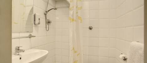 A bathroom with a white sink, a toilet, and a shower with a yellow shower curtain.