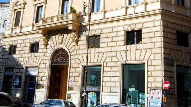 A multi-story building with a classical architectural style, featuring a central entrance with an arched doorway and a balcony. - Hotel Primavera (Rome)