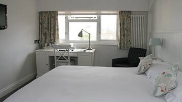 Una habitación de hotel con cama, escritorio y silla.