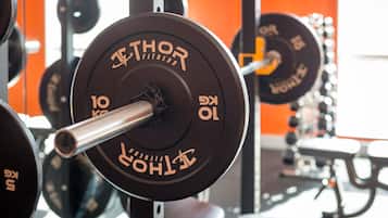 A weightlifting bench with a barbell and weight plates labeled "THOR FITNESS."