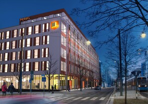Un bâtiment moderne, facilement reconnaissable à son grand panneau « Motel L », à ses larges fenêtres et à sa façade en verre.
