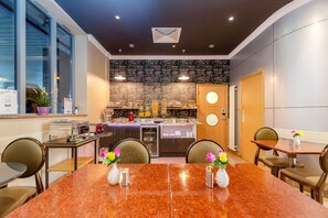 Un comedor con una mesa de mármol, sillas y vistas a la cocina.