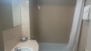 A bathroom with a sink, toilet, and shower area.