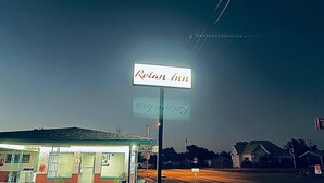 A motel sign with the name "Rolan Inn" and a 'VACANCY' sign beside it.