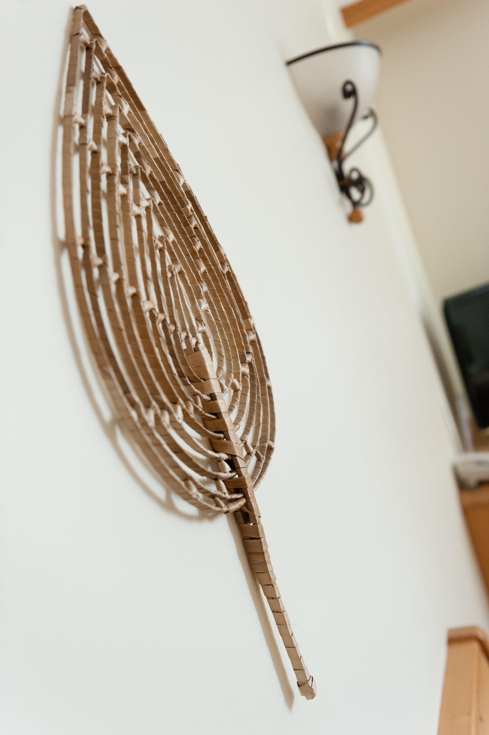 A wall-mounted decorative piece resembling a leaf.