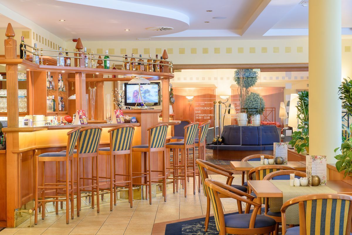 Zona de bar con muebles de madera, un televisor y un cartel que indica que está abierto.