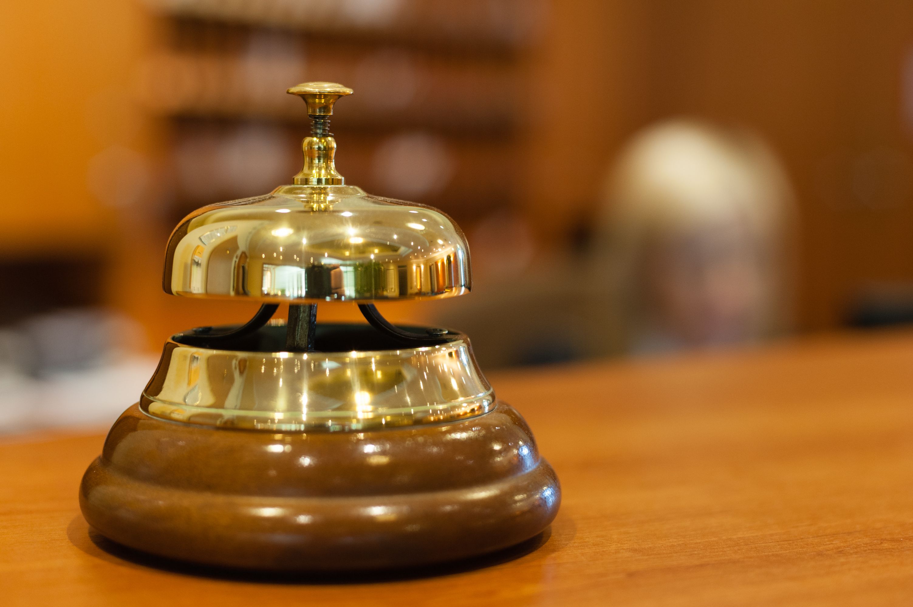 A wooden desk with a brass bell on top.